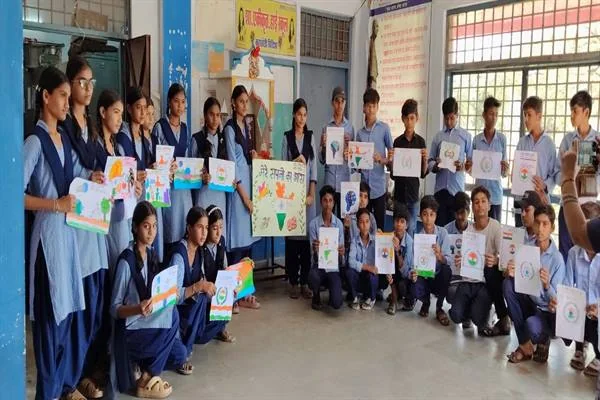 स्कूल के कमरे में छात्र-छात्राएं हाथों में रंगीन चित्र और पोस्टर लेकर समूह में खड़े और बैठे हैं
